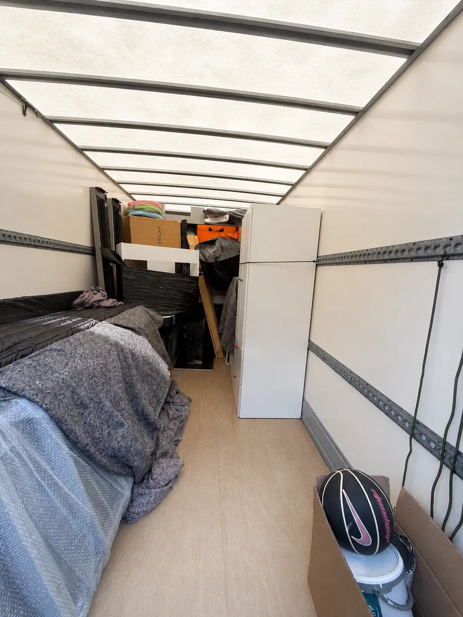 Inside a loaded Leaways Removals van with a fridge freezer, wrapped furniture and boxes