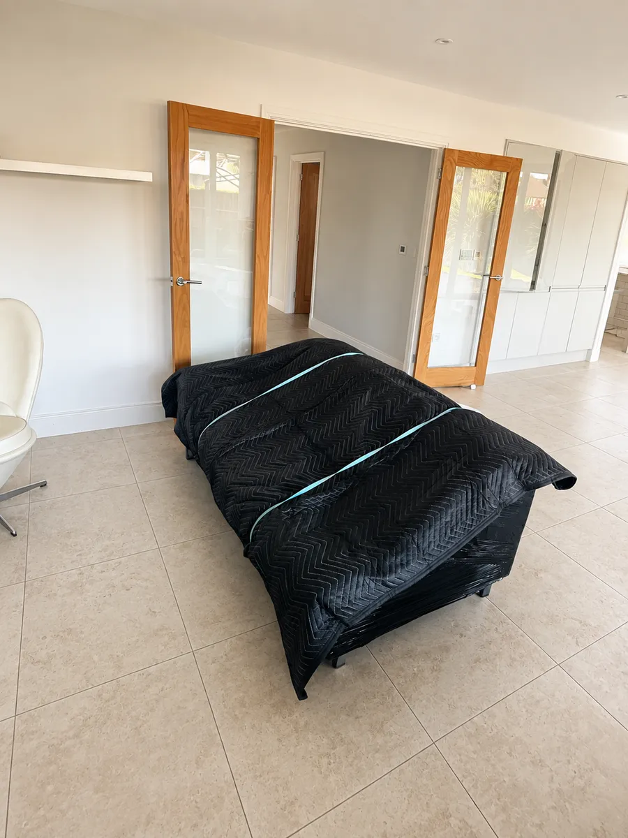 Client's sofa fully protected in a padded cover by Leaways Removals, ready for transit