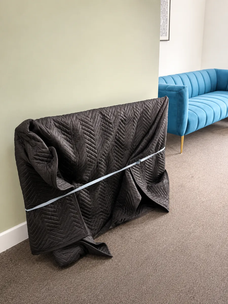 Flat screen TV protected in a padded quilted cover by Leaways Removals during a home move